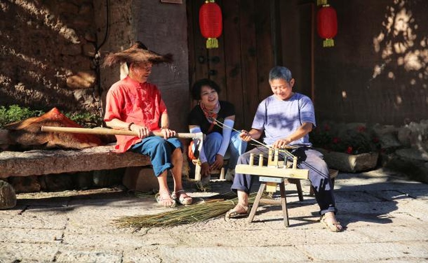 古村手工艺人吸引游客驻足观赏。.jpg